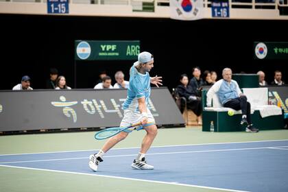 Marco Trungelliti impactando ante Hyeon Chung, con Javier Frana siguiendo atento la acción, el último fin de semana en Corea del Sur