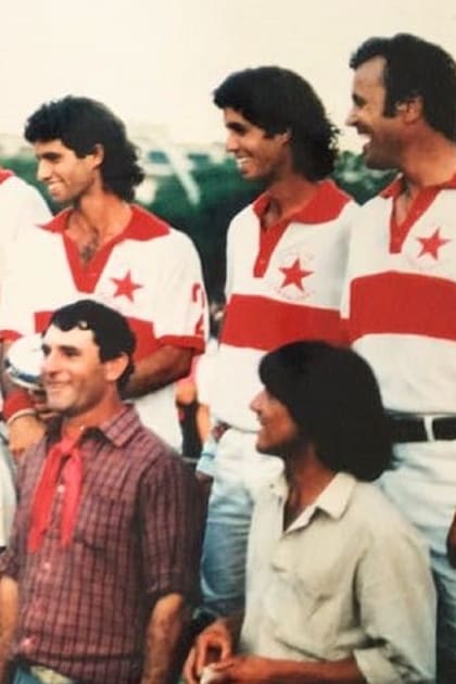 Marcos Heguy sostiene la copa individual tras conseguir la gloria para Indios Chapaleufú en el Argentino Abierto de 1986 y escucha a Carlos Bilardo, flamante campeón mundial como DT en México.
