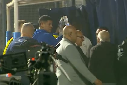 Marcos Rojo, habitual capitán de Boca pero identificado con Estudiantes por su pasado, ofrece una botella de agua a hinchas de Gimnasia agobiados por gases lacrimógenos en el Bosque de La Plata.