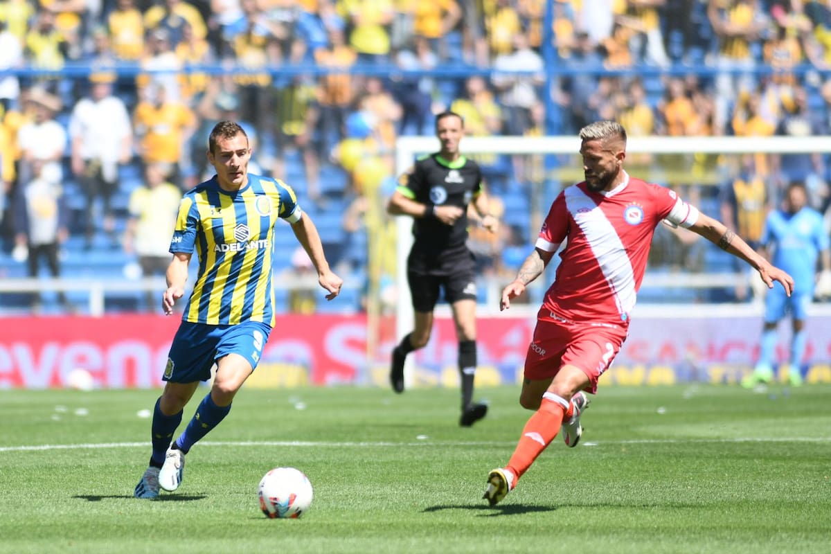 Marcos Ruben intenta frenar el avance de Elías Gómez; Argentinos pisó fuerte en el Gigante de Arroyito