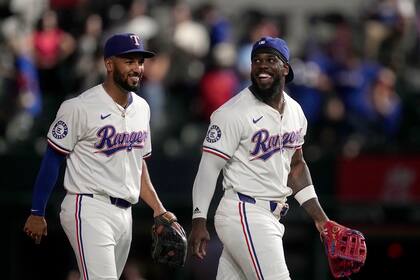 Marcus Semien (izquierda) y el cubano Adolis García festejan el triunfo de los Rangers de Texas, sobre los Azulejos de Toronto, en el encuentro del miércoles 18 de septiembre de 2024 (AP Foto/Tony Gutiérrez)