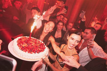 María, fundadora y dueña de
la marca homónima, rodeada
por amigos y con una torta
con crema, frutillas y bengala,
símbolo de celebración