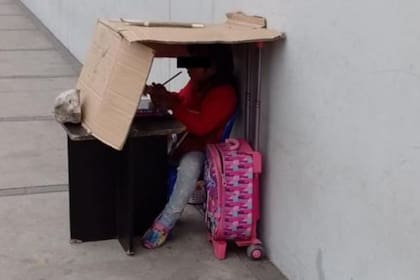 María pasa el tiempo en un escenario improvisado mientras su papá trabaja
