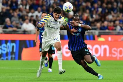 Mariano Troilo lucha por la pelota con Ange-Yoan Bonny (14), mientras Lautaro Martínez observa la jugada detrás, en Inter - Parma, por la Serie A