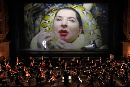 Marina Abramovic, en la cama, durante una escena de "Las siete muertes de Maria Callas", que se estrenó esta semana en Munich. En la pantalla, cuando W. Dafoe le rodea el cuello con víboras para estrangularla como Desdémona, los serpenteantes animales se manchan con el lápiz labial de su cara