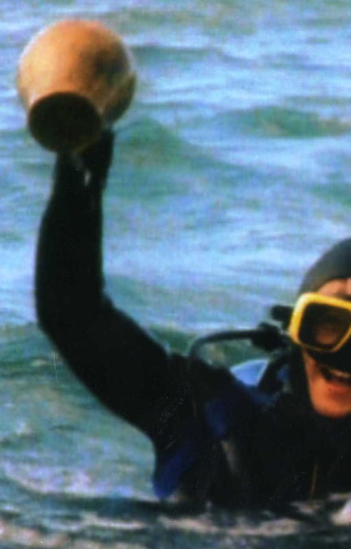 Mario Brozoski, uno de los cuatro intrépidos adolescentes que encontraron el buque, rescata del fondo del mar un jarrón -intacto- del siglo XVIII