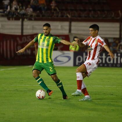 Mario López, central de Aldosivi, sale con la pelota ante la presión de Bruno Sepúlveda, delantero de Barracas Central