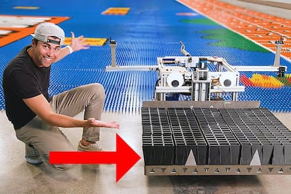 Mark Rober junto a Dominator, el robot que puede colocar unas 300 piezas de dominó por vez de forma rápida y eficiente