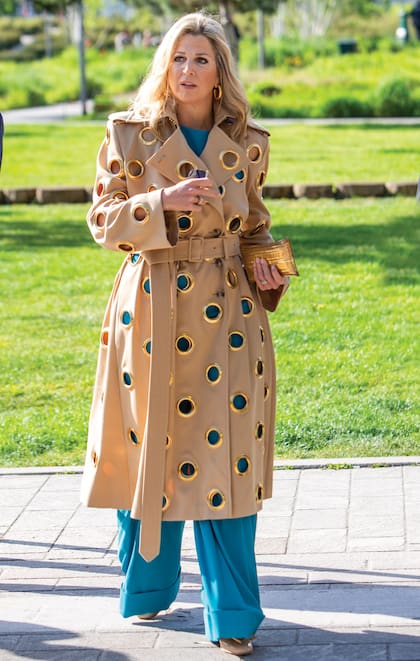 Martes 18. Máxima lució un conjunto de pantalón y top turquesa, un trench de gabardina original con aberturas enforma de argollas de la firma danesa Claes Iversen, un clutch artesanal de Begüm Khan, zapatos de charol de Ferragamo y lentes de sol de Cartier.