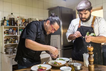 Martín Altamirano y su colaborador Flavio Bravo decoran uno de los platos del menú.