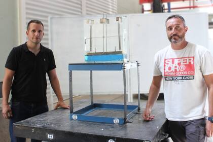 Martin Domizio y Gabriel Houri con un prototipo del Sistema de Amortiguadores Líquidos Sintonizados de Alta Frecuencia (ALS-AF).