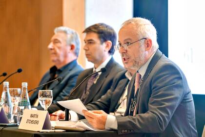 Martín Etchevers lee el informe de libertad de prensa en la asamblea de ADEPA; a su lado, el presidente de la entidad, Daniel Dessein