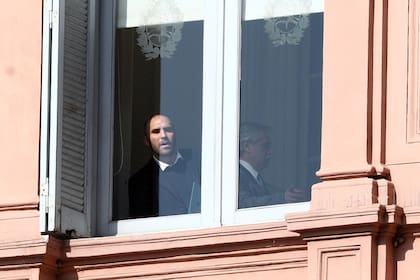 Martín Guzmán, junto a Alberto Fernández, asomado a una ventana de la Casa Rosada