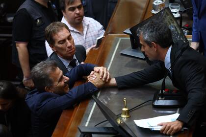 Martín Menem, titular de la Cámara de Diputados, recibe el saludo de los macristas Cristian Ritondo y Diego Santilli después de haber aprobado en general la ley ómnibus