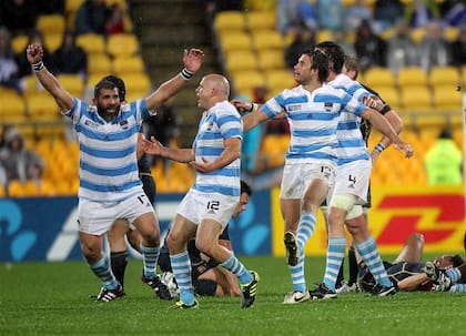 Martín Scelzo alza los brazos y festeja con el capitán Felipe Contepomi, en un triunfo vital ante Escocia