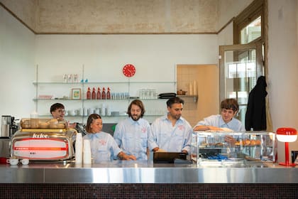 Martín, su socio Diego (der.) y el staff del café en su barra