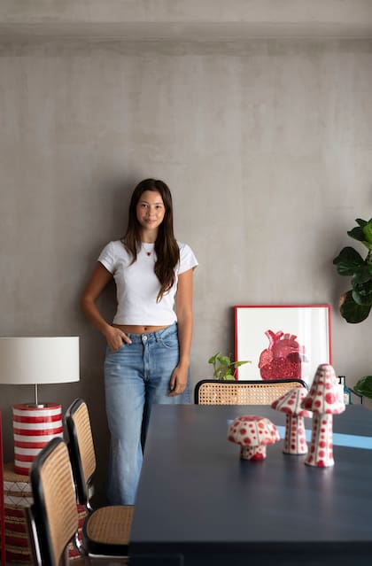 Martina junto a uno de los muchos detalles en rojo: el corazón bordado (Barbaridad) en la cabecera del comedor.