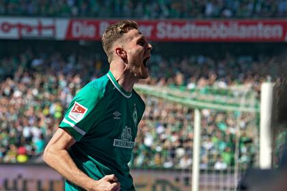 Marvin Ducksch del Werder Bremen festeja tras anotar un gol ante Jahn Regensburg en la segunda división de Alemania, el domingo 15 de mayo de 2022. (Carmen Jaspersen/dpa vía AP)