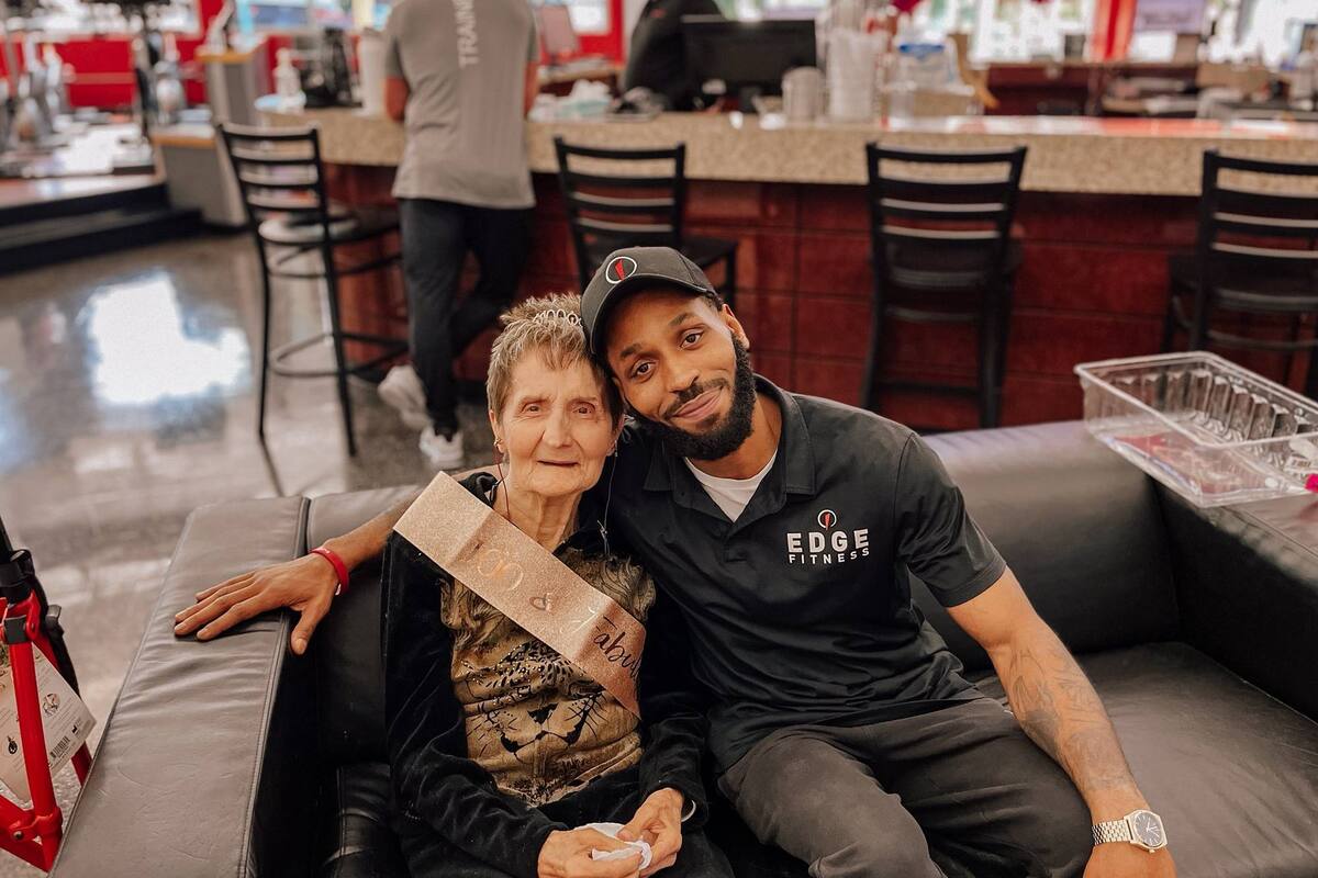 Mary Coroneos en el festejo de sus 100 años junto a su entrenador
