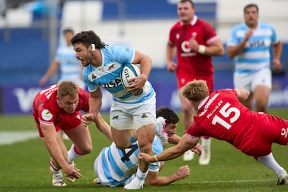 Mateo Carreras intenta evitar dos tackles; los Pumas han sido superiores a los galeses en la etapa inicial del encuentro en San Juan por el Nations Championship.