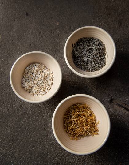 Material vegetal en cuencos: caléndula y manzanilla, avena y flores de lavanda secas