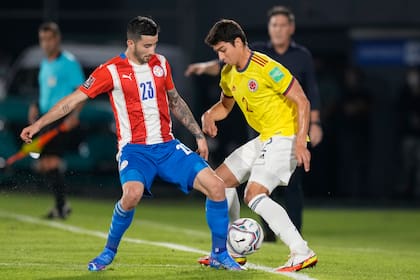 Mathias Villasanti de Paraguay, y Andrés Román, de Colombia, disputan por la pelota en el duelo por las eliminatorias