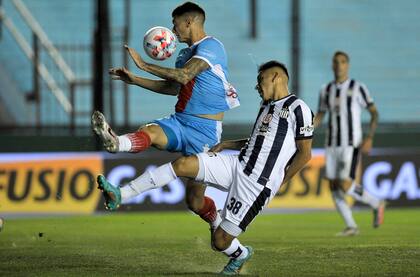 Matías Godoy, de Talleres, cruza a Lucas Suárez.