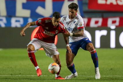 Matías Suarez disputa el balón con Claudio Yacob.