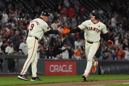 Matt Chapman, de los Gigantes de San Francisco (derecha), recibe la felicitación del entrenador de tercera base Matt Williams (9) tras sacudir un jonrón en el sexto inning del juego de la MLB que enfrentó a su equipo con los Medias Blancas de Chicago, en San Francisco, el 19 de agosto de 2024. (AP Foto/Jeff Chiu)