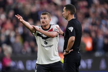 Matthijs de Ligt (izquierda) protesta la decisión del árbitro David Coote al pitar un penal a favor de West Ham en la Liga Premier, el domingo 27 de octubre de 2024, en Londres. (John Walton/PA vía AP)