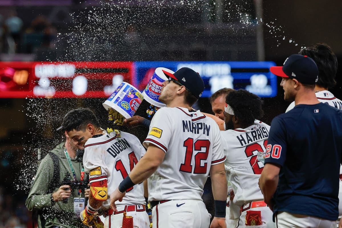 Mauricio Dubón, izquierda, de los Bravos de Atlanta, es celebrado por sus compañeros después de bate