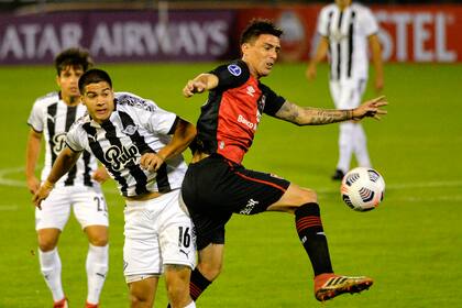 Mauro Formica, de Newell´s, domina la pelota ante la marca de Iván Ramírez, de Libertad, durante el partido que ambos equipos disputan en el Coloso Marcelo Bielsa, por la fase de grupos de la Copa Sudamericana.
