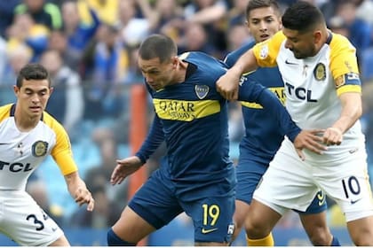 Mauro Zárate disputa la pelota con Néstor Ortigoza, en un duelo reciente entre Boca y Rosario Central