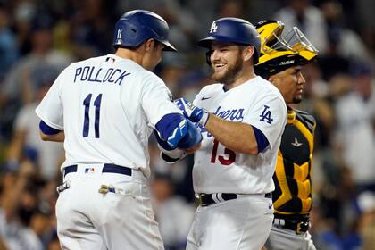 Max Muncy (centro) celebra un jonrón de tres carreras con su compañero de los Dodgers de Los Ángeles AJ Pollock en el cuarto inning del juego de la MLB que enfrentó a su equipo con los Piratas de Pittsburgh, el 18 de agosto de 2021, en Los Ángeles. (AP Foto/Marcio José Sánchez)