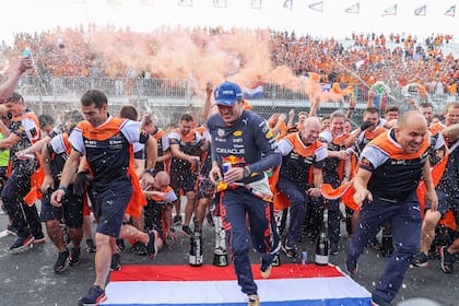 Max Verstappen se lanza en carrera después de celebrar la victoria del Gran Premio de los Países Bajos con los integrantes del equipo Red Bull Racing; de fondo, la multitud le ofrece color al festejo del campeón