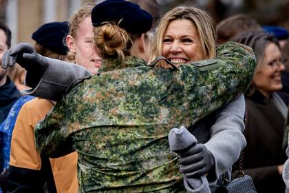 Máxima, con abrigo largo en tono gris, guantes y el gorro en la mano, abraza a su hija mayor, en un gesto efusivo y fuera de protocolo