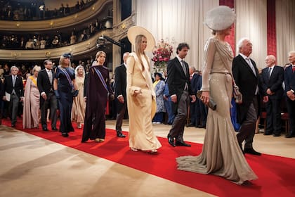 Máxima ingresó al Parlamento seguida de sus hijas. La reina Máxima llevó un vestido realizado por Jan Taminiau, en georgette y crepé completamente bordado con cuentas de vidrio, que había lucido por primera vez en 2011 en este mismo acto. El tocado de Berry Rutjes Jr. tiene aplicaciones de flores y plumas largas