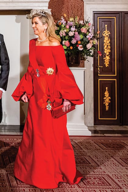 Máxima lució sobre su vestido la banda de la Orden de la Legión de Honor francesa, en color rojo, y un collar de perlas que había pertenecido a la reina Juliana y luego a su hija Beatriz.