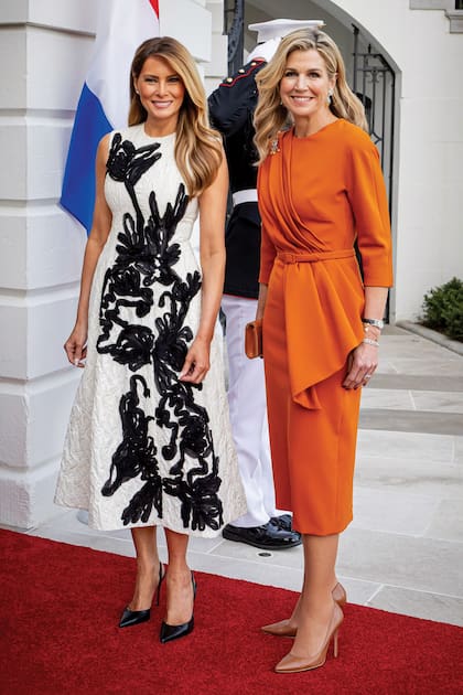 Máxima rindió homenaje al color nacional de Países Bajos con un vestido midi con falda lápiz, cintura marcada y drapeado de Claes Iversen. El naranja, además, es uno de sus colores favoritos ya que adora los colores vibrantes. Melania Trump, en tanto, apostó por un vestido midi decorado con flores creadas con cinta de gasa a contratono de Erdem