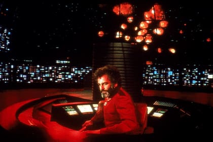 Maximilian Schell en el comando de su nave en un tramo de El abismo negro; detrás aparece una lluvia de meteoritos