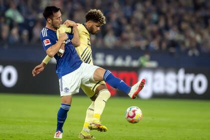 Maya Yoshida del Schalke y Georginio Rutter del Hoffenheim pelean por el balón en el encuentro de la Bundesliga el viernes 14 de octubre del 2022. (Bernd Thissen/dpa via AP)