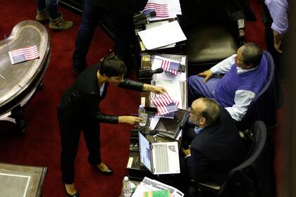 Mayra Mendoza le entrega banderas de los Estados Unidos a Fernando Iglesias y Toty Flores