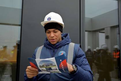 Mbappé observa un folleto con el detalle de las instalaciones.