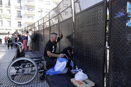 Meda Florián, junto a un manifestante, a la sombra de las vallas del Congreso
