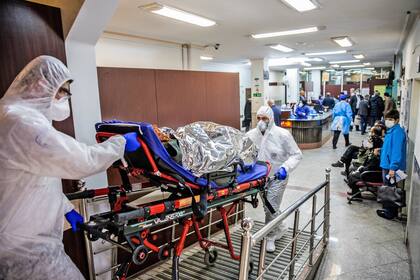 Médico en un hospital de Irán trasladan a un paciente infectado con coronavirus