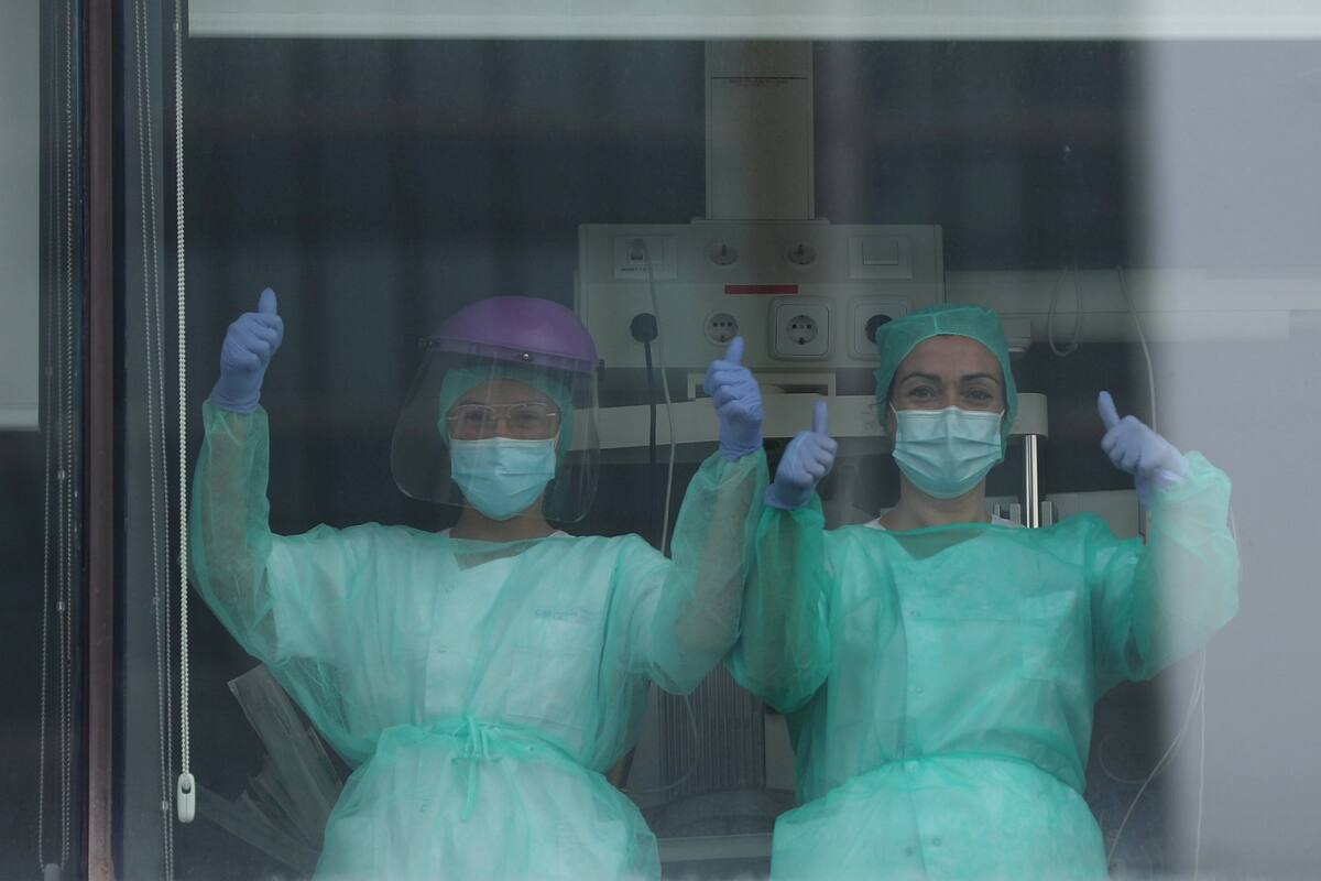 Médicos del Hospital La Paz de Madrid saludan después de un minuto de silencio en memoria del jefe de cirugía, fallecido tras ser infectado por el Covid-19