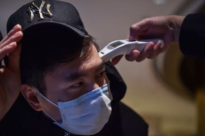 Médicos examinan a la gente en la ciudad de Wuhan, epicentro del virus
