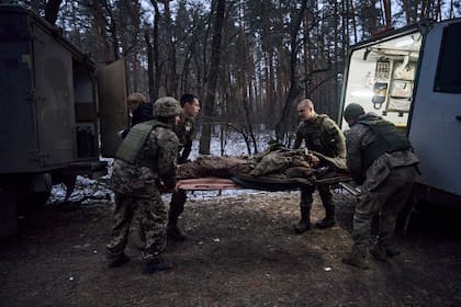 Médicos militares evacuan a un soldado gravemente herido en una batalla con los invasores rusos cerca de Kremenna en la región de Lugansk, Ucrania, el viernes 13 de enero de 2023.(AP/LIBKOS)