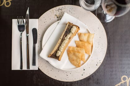 Médula de llama rostizada con puré de berenjenas asadas y chips crocantes.