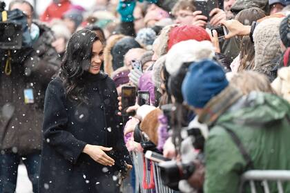 Meghan eligió un vestido de seda y chifon midi bordado con flores y pájaros de Óscar de La Renta que accesorizó con clutch de Ralph Lauren y botas de gamuza de Sarah Flint.